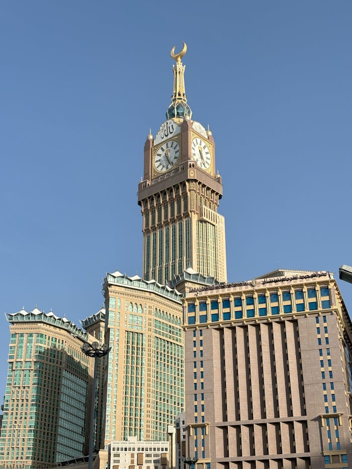 Stunning architectural capture of the Abraj Al Bait Towers under clear skies in Makkah, Saudi Arabia.